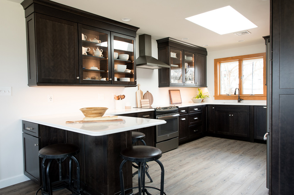 Inspiration for a mid-sized contemporary u-shaped eat-in kitchen in Philadelphia with an undermount sink, shaker cabinets, dark wood cabinets, quartz benchtops, stainless steel appliances, medium hardwood floors, a peninsula, grey floor and white benchtop.