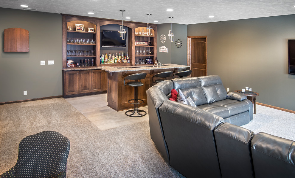 This is an example of a mid-sized transitional open concept family room in Omaha with a game room, brown walls, carpet and a wall-mounted tv.