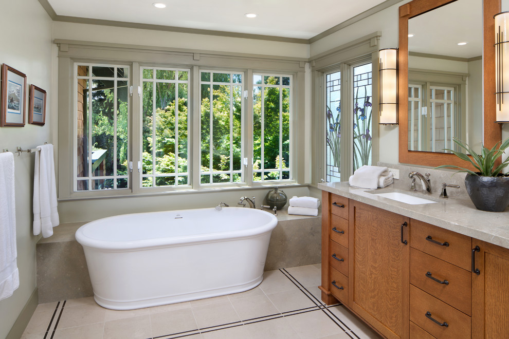 Large arts and crafts master bathroom in San Francisco with shaker cabinets, medium wood cabinets, a freestanding tub, an undermount sink, grey walls, porcelain floors and beige floor.