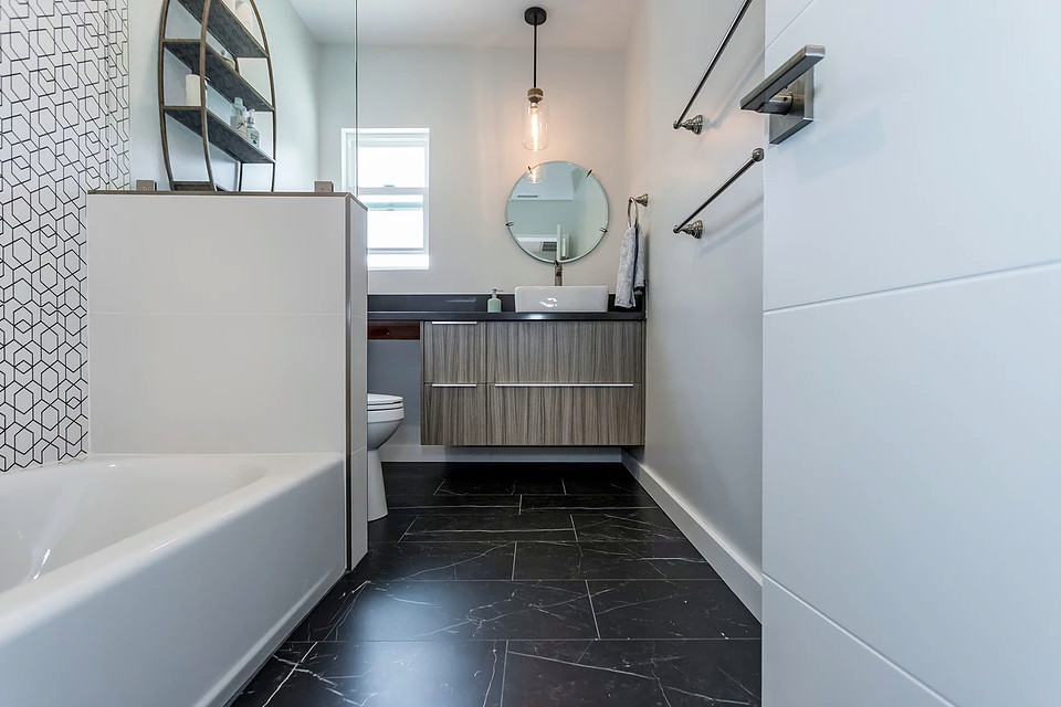 Mid-sized contemporary bathroom in Los Angeles with flat-panel cabinets, light wood cabinets, an alcove tub, a shower/bathtub combo, a two-piece toilet, black and white tile, ceramic tile, grey walls, marble floors, a vessel sink, soapstone benchtops, black floor, a shower curtain and black benchtops.