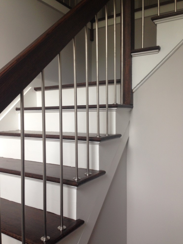 Photo of a contemporary wood l-shaped staircase in New York with painted wood risers.