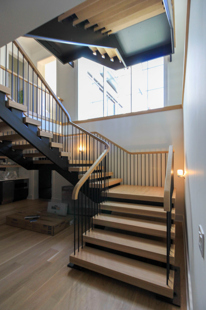 Источник вдохновения для домашнего уюта: огромная лестница на больцах в стиле модернизм с деревянными ступенями, перилами из смешанных материалов и стенами из вагонки