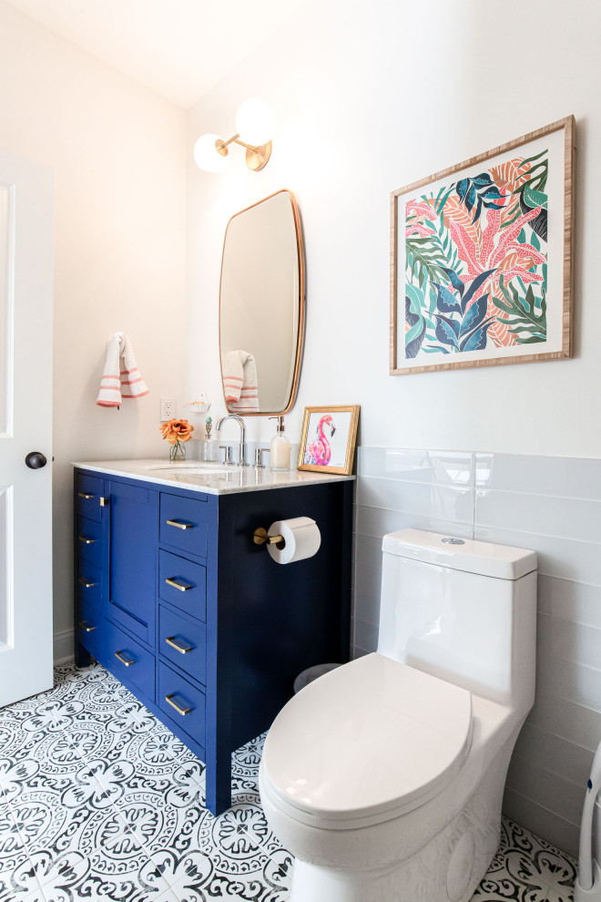 Cette image montre une salle de bain design de taille moyenne pour enfant avec un placard à porte shaker, des portes de placard bleues, une baignoire indépendante, un combiné douche/baignoire, WC à poser, un carrelage noir et blanc, des carreaux de béton, un mur blanc, carreaux de ciment au sol, un lavabo encastré, un plan de toilette en marbre, un sol multicolore, une cabine de douche avec un rideau, un plan de toilette blanc, une niche, meuble simple vasque et meuble-lavabo sur pied.