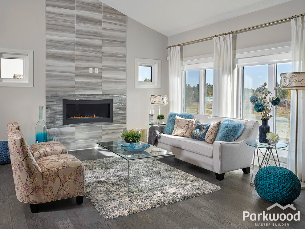 Inspiration for a mid-sized eclectic open concept living room in Edmonton with grey walls, medium hardwood floors, a standard fireplace and a tile fireplace surround.