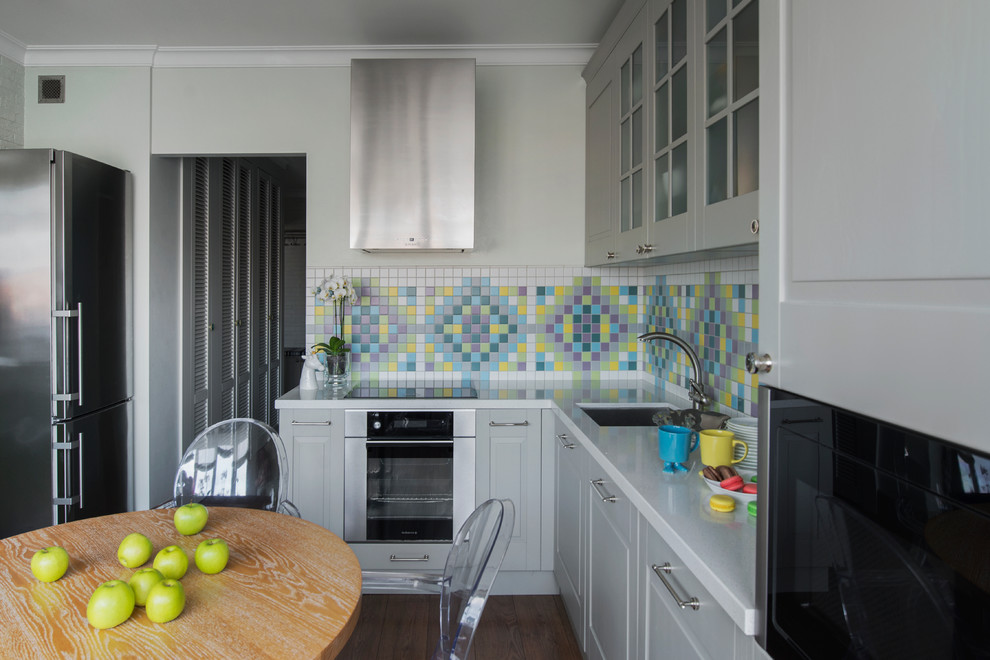 This is an example of a mid-sized contemporary l-shaped eat-in kitchen in Moscow with an undermount sink, raised-panel cabinets, grey cabinets, multi-coloured splashback, stainless steel appliances and no island.