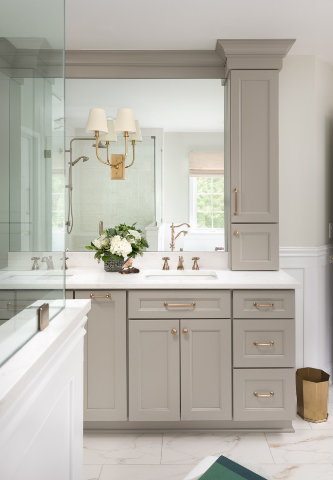 This is an example of a large transitional master bathroom in Chicago with recessed-panel cabinets, beige cabinets, a freestanding tub, a corner shower, a one-piece toilet, white tile, ceramic tile, beige walls, porcelain floors, an undermount sink, engineered quartz benchtops, white floor, a hinged shower door, white benchtops, a shower seat, a double vanity, a built-in vanity and decorative wall panelling.