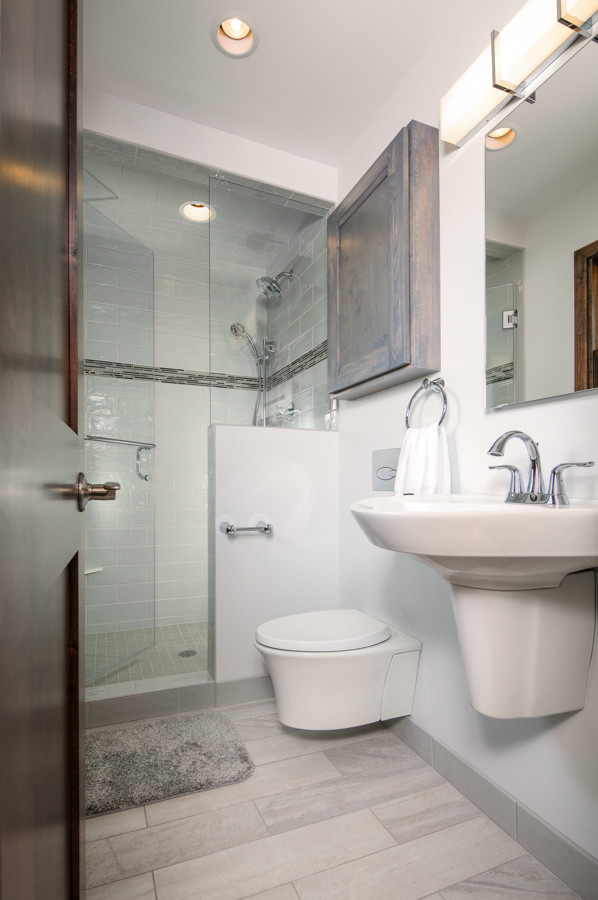 Small traditional master bathroom in Omaha with flat-panel cabinets, grey cabinets, an alcove shower, a wall-mount toilet, gray tile, ceramic tile, white walls, porcelain floors, a wall-mount sink, grey floor and a hinged shower door.