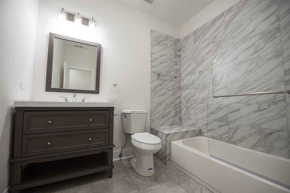This is an example of a small 3/4 bathroom in Chicago with shaker cabinets, brown cabinets, a corner shower, a one-piece toilet, beige tile, marble, white walls, ceramic floors, a drop-in sink, grey floor, a hinged shower door, a single vanity and a freestanding vanity.