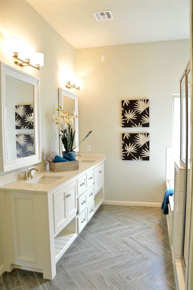 Mid-sized transitional master bathroom in Oklahoma City with recessed-panel cabinets, grey cabinets, an alcove tub, an alcove shower, a two-piece toilet, beige tile, white tile, porcelain tile, beige walls, porcelain floors, an undermount sink, engineered quartz benchtops, beige floor and a hinged shower door.