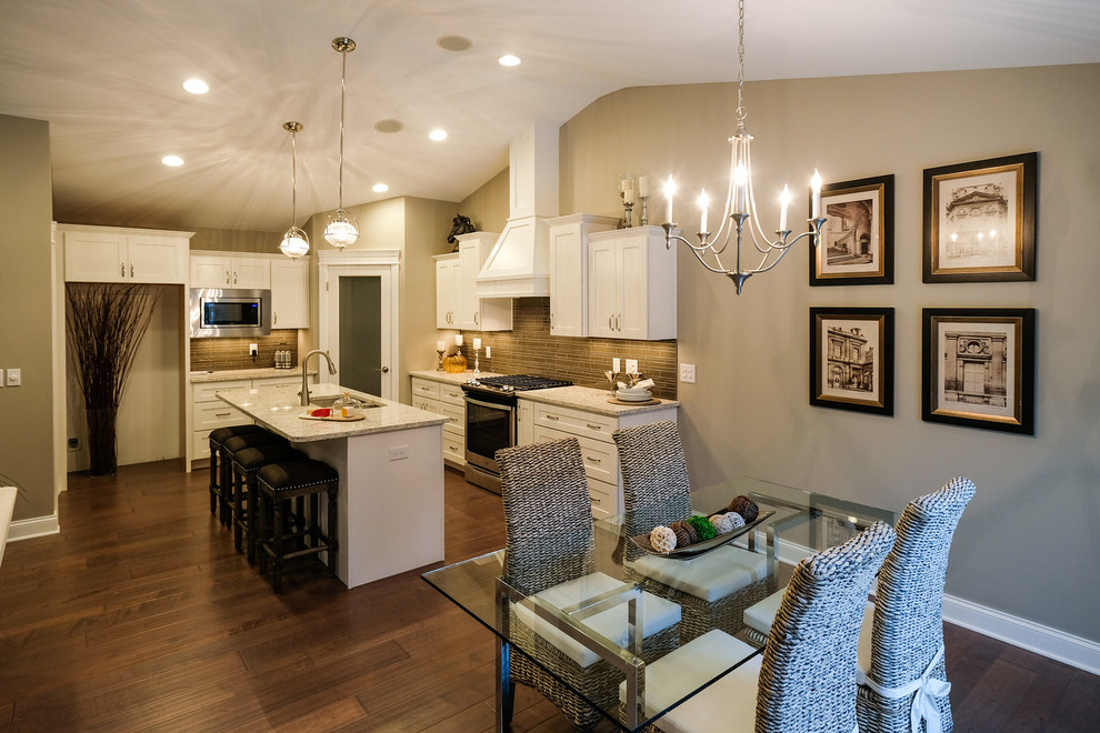 Eat-in kitchen - mid-sized transitional l-shaped dark wood floor and brown floor eat-in kitchen idea with an undermount sink, recessed-panel cabinets, white cabinets, quartz countertops, brown backsplash, stainless steel appliances, an island and white countertops