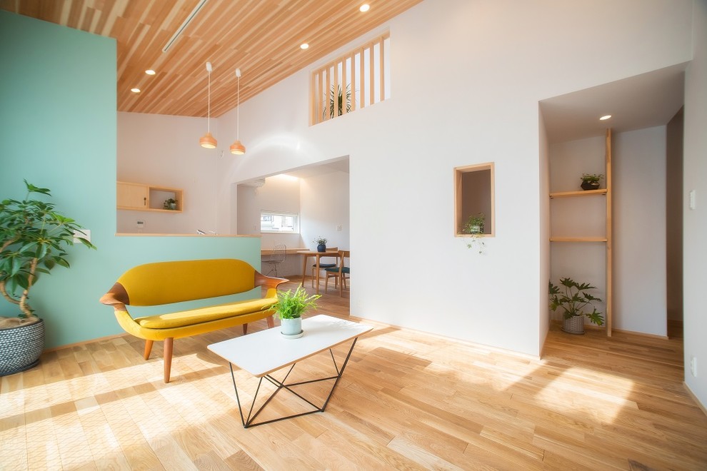 Scandinavian living room in Other with blue walls, light hardwood floors and brown floor.