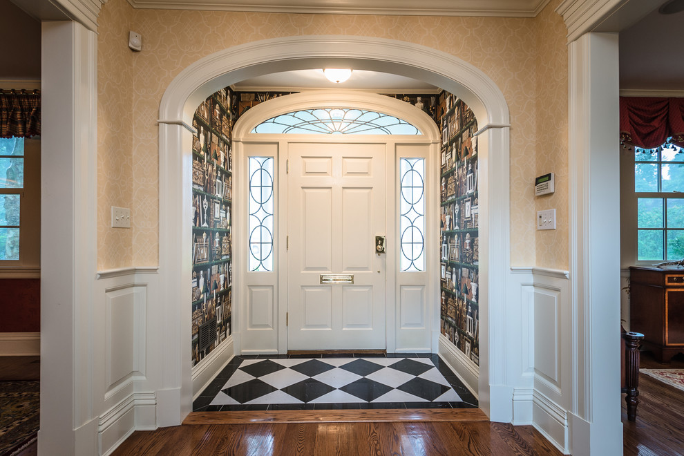 Inspiration for a large traditional front door in New York with yellow walls, medium hardwood floors, a single front door, a white front door and brown floor.