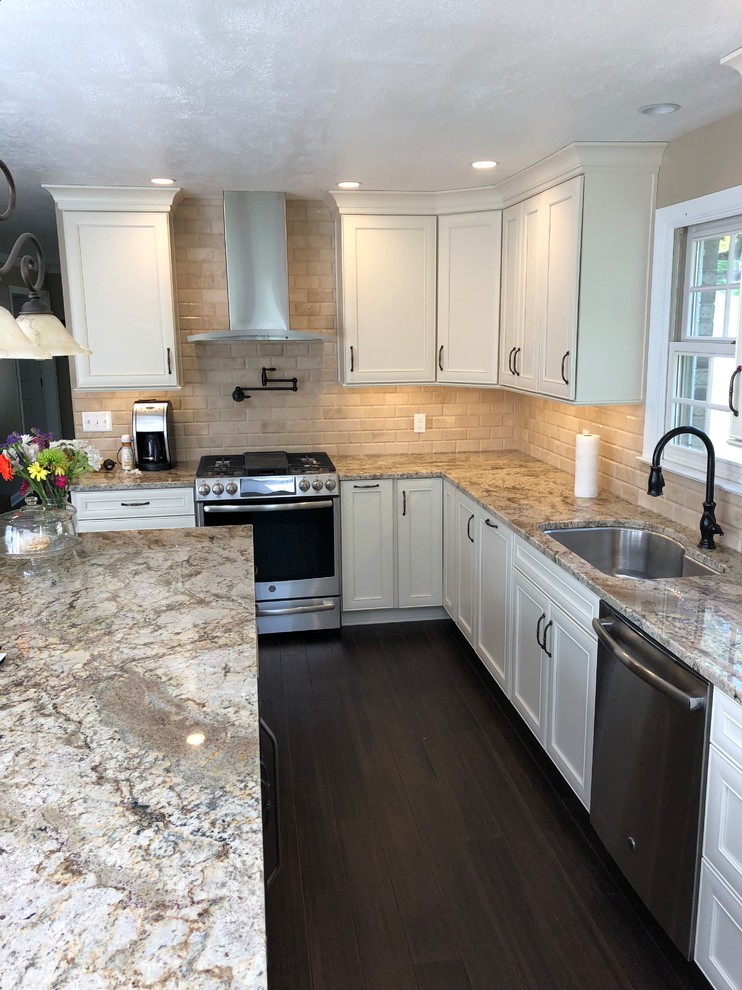 Kitchen - modern dark wood floor and brown floor kitchen idea with an undermount sink, recessed-panel cabinets, beige cabinets, granite countertops, beige backsplash, stone tile backsplash, stainless steel appliances, an island and multicolored countertops