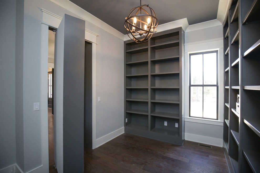 Inspiration for a mid-sized transitional home office in Raleigh with grey walls, brown floor, a library, dark hardwood floors and no fireplace.