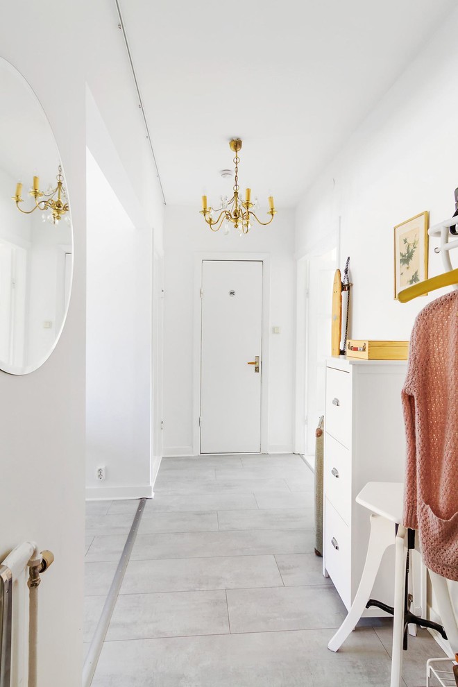 Photo of a large eclectic hallway in Orebro with white walls and ceramic floors.