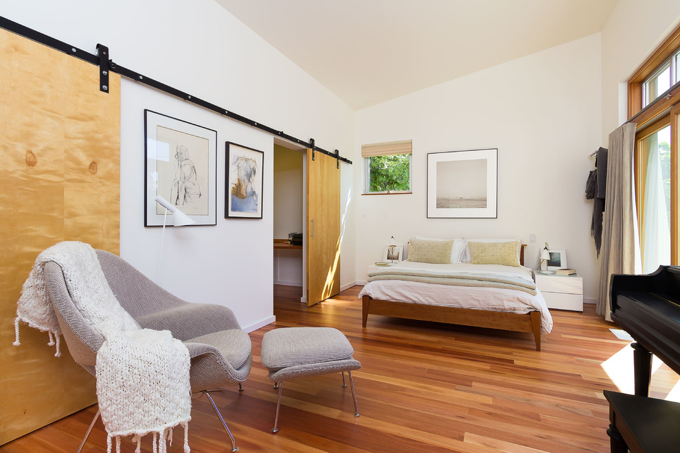 Mid-sized contemporary bedroom in Seattle with white walls, medium hardwood floors and brown floor.
