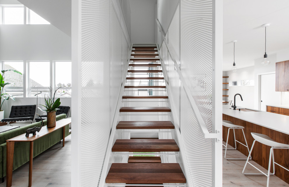 Ejemplo de escalera suspendida vintage de tamaño medio sin contrahuella con escalones de madera y barandilla de metal
