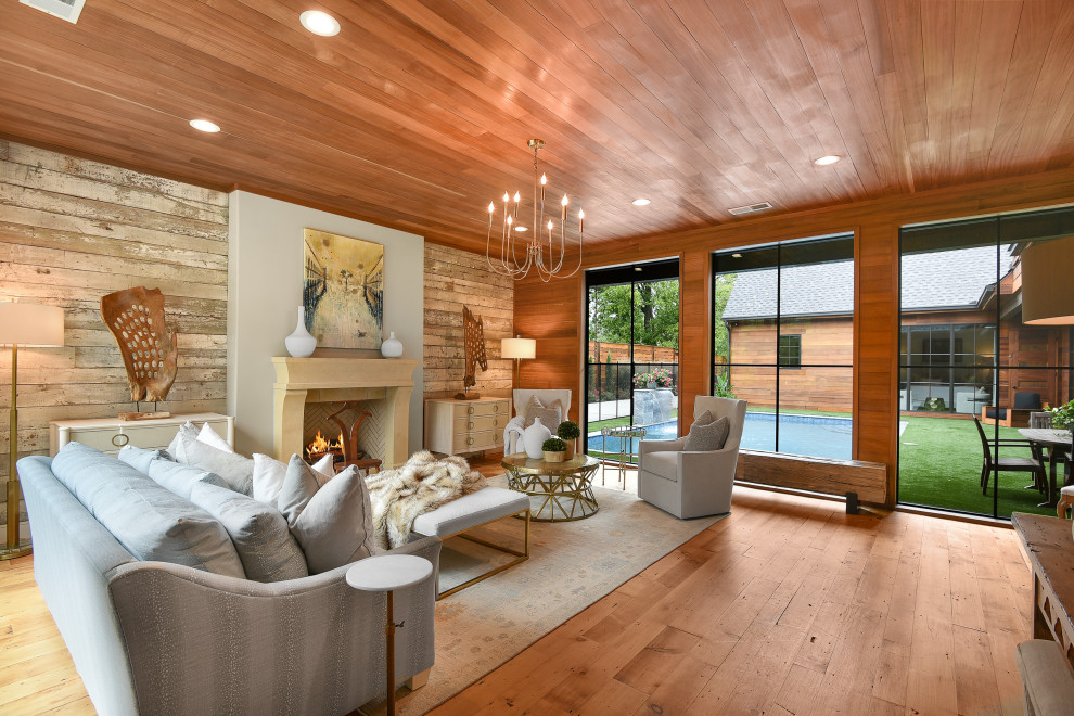 This is an example of a large country formal open concept living room in Atlanta with white walls, medium hardwood floors, a standard fireplace, no tv, wood and wood walls.