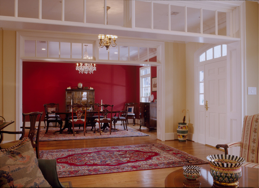Large arts and crafts separate dining room in Houston with red walls and light hardwood floors.
