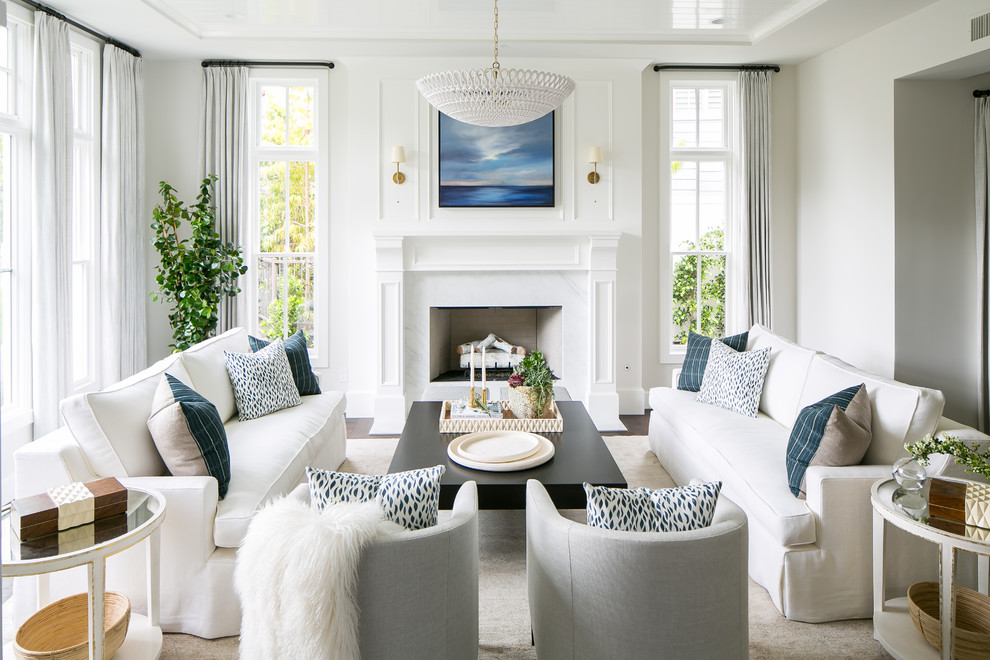 This is an example of a beach style living room in Orange County with white walls, dark hardwood floors, a standard fireplace and brown floor.