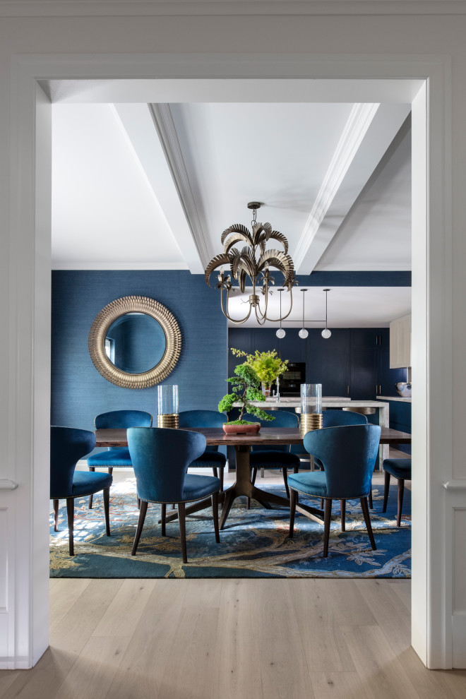 Foto di una grande sala da pranzo aperta verso la cucina contemporanea con pareti blu, parquet chiaro, travi a vista e carta da parati