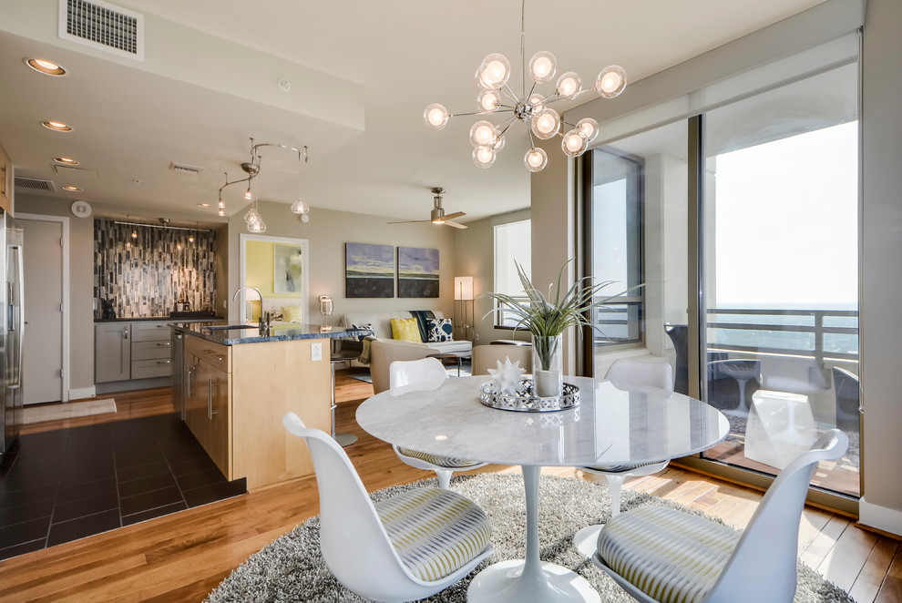 Open concept kitchen - small transitional galley light wood floor open concept kitchen idea in Austin with a double-bowl sink, flat-panel cabinets, light wood cabinets, granite countertops, gray backsplash, porcelain backsplash, stainless steel appliances and an island