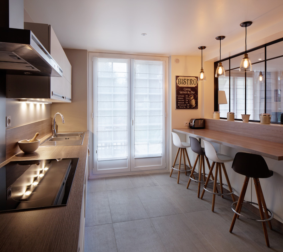 Large contemporary galley separate kitchen in Paris with an undermount sink, flat-panel cabinets, white cabinets, laminate benchtops, panelled appliances and no island.