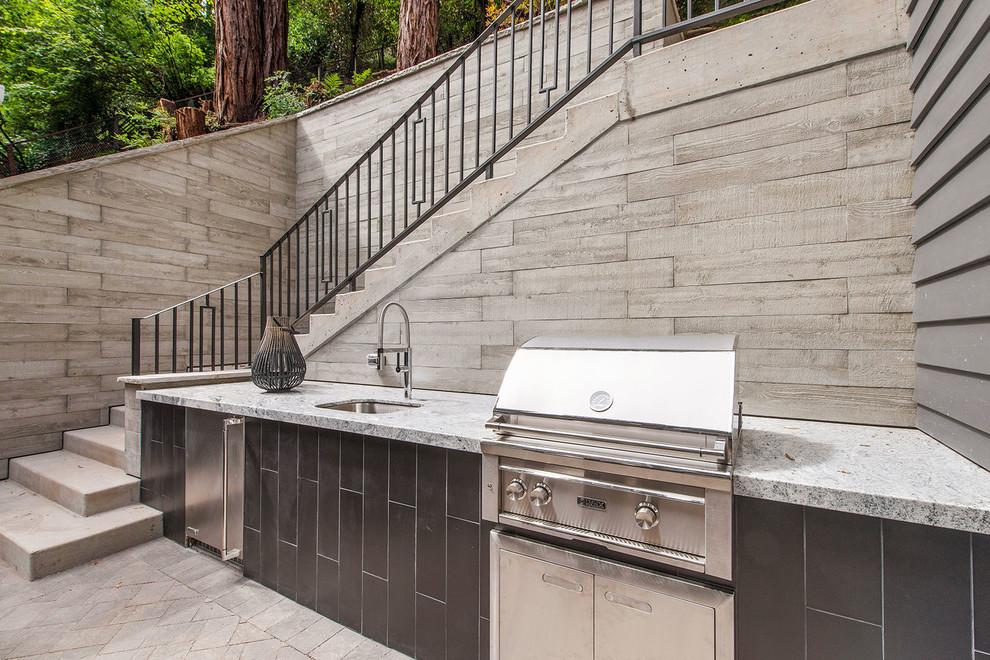 This is an example of a mid-sized transitional courtyard patio in San Francisco with an outdoor kitchen, concrete pavers and no cover.