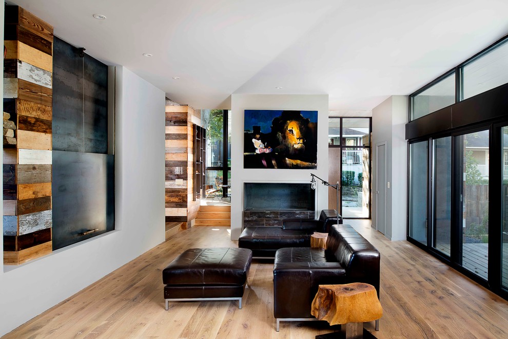 Contemporary family room in Atlanta with white walls, light hardwood floors, a ribbon fireplace and a concealed tv.