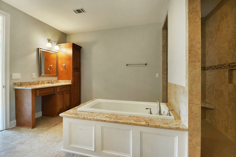 Drop-in bathtub - mid-sized transitional master beige tile and porcelain tile porcelain tile drop-in bathtub idea with an undermount sink, raised-panel cabinets, medium tone wood cabinets, granite countertops and gray walls