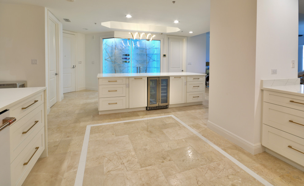 Photo of a large transitional u-shaped eat-in kitchen in Miami with an undermount sink, shaker cabinets, white cabinets, quartz benchtops, multi-coloured splashback, ceramic splashback, white appliances, travertine floors, with island, beige floor, white benchtop and coffered.