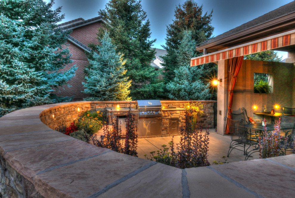 Inspiration for a mid-sized traditional backyard patio in Denver with a fire feature, concrete slab and an awning.