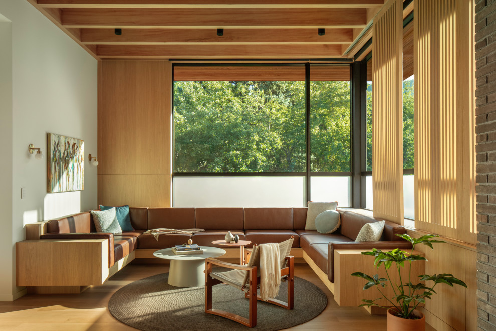 This is an example of a midcentury open concept living room in Denver with light hardwood floors, wood and wood walls.