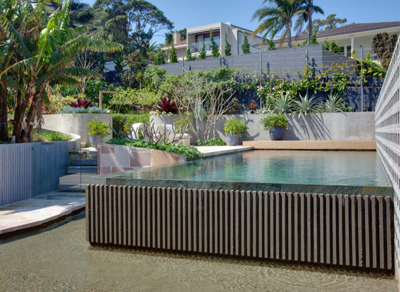 Design ideas for a mid-sized modern backyard rectangular lap pool in Sydney with natural stone pavers.
