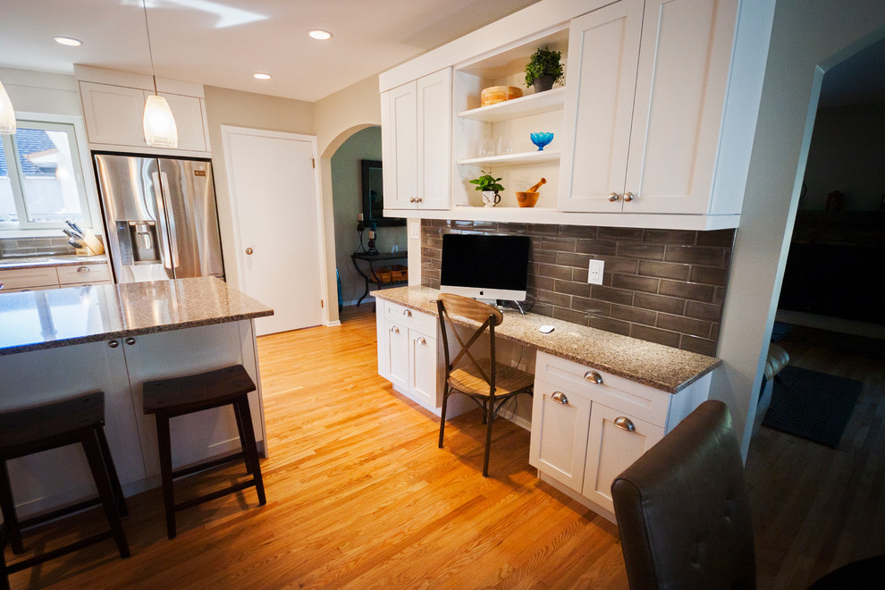 Inspiration for a mid-sized transitional l-shaped light wood floor eat-in kitchen remodel with a double-bowl sink, white cabinets, quartz countertops, brown backsplash, ceramic backsplash, stainless steel appliances, an island and shaker cabinets