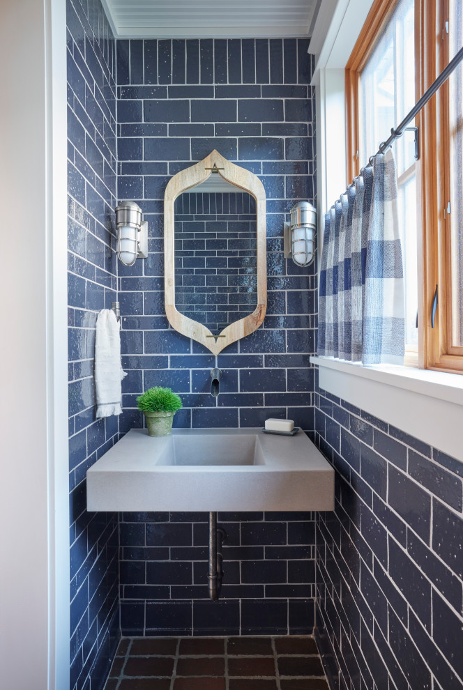 他の地域にあるエクレクティックスタイルのおしゃれなトイレ・洗面所 (青いタイル、レンガの床、壁付け型シンク、コンクリートの洗面台、グレーの洗面カウンター) の写真