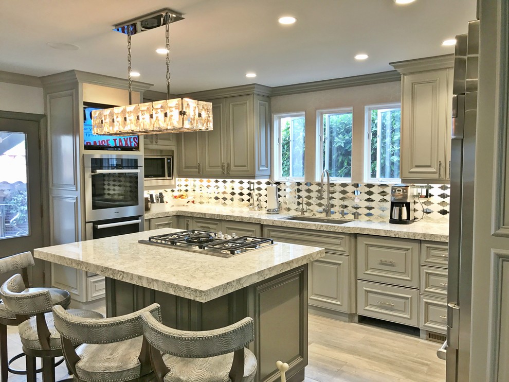 Large transitional l-shaped separate kitchen in San Diego with an undermount sink, raised-panel cabinets, grey cabinets, granite benchtops, white splashback, ceramic splashback, stainless steel appliances, vinyl floors, multiple islands and grey floor.
