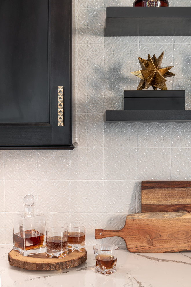 Example of a large transitional l-shaped dark wood floor and brown floor enclosed kitchen design in St Louis with a farmhouse sink, shaker cabinets, white cabinets, quartz countertops, white backsplash, subway tile backsplash, stainless steel appliances, an island and white countertops