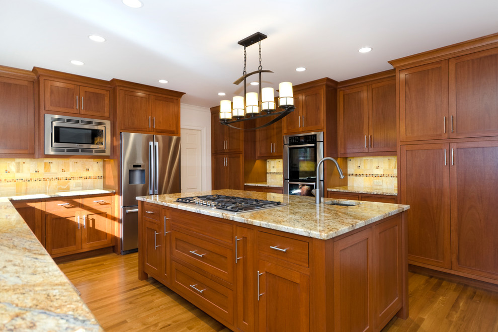 Photo of an arts and crafts u-shaped open plan kitchen in DC Metro with recessed-panel cabinets, dark wood cabinets, granite benchtops, beige splashback, stone tile splashback and stainless steel appliances.