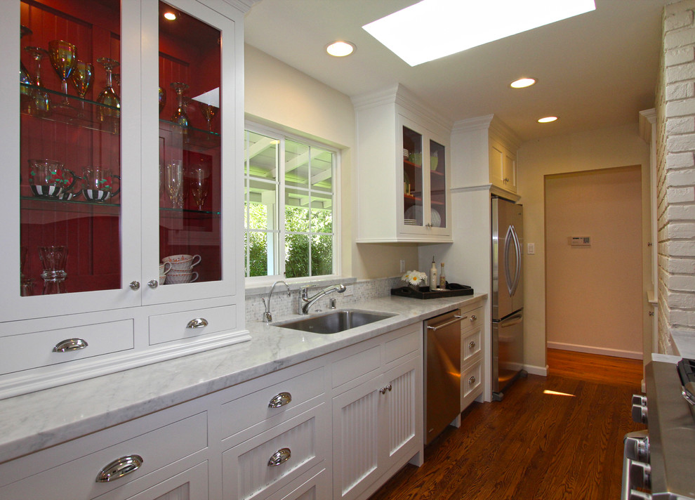 Photo of a small country galley eat-in kitchen in San Francisco with an undermount sink, shaker cabinets, white cabinets, marble benchtops, grey splashback, stainless steel appliances, medium hardwood floors and no island.