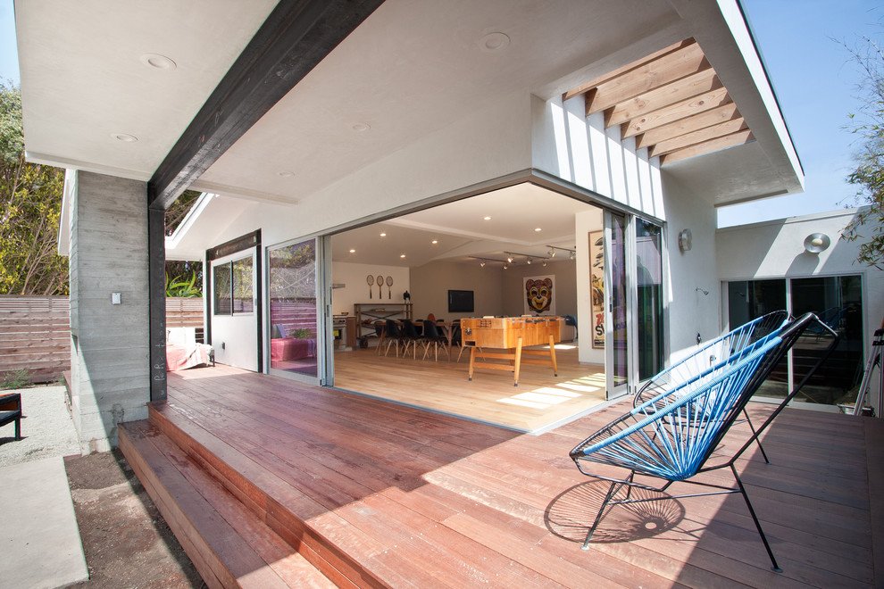 This is an example of a mid-sized contemporary courtyard deck in Los Angeles with a roof extension.