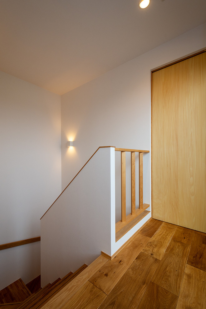 Inspiration for a small wood l-shaped staircase in Other with wood risers, wood railing and wallpaper.