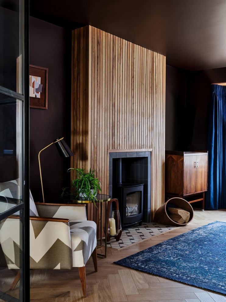 Idee per un soggiorno contemporaneo con camino classico, pareti marroni, parquet chiaro, cornice del camino in legno e pavimento beige