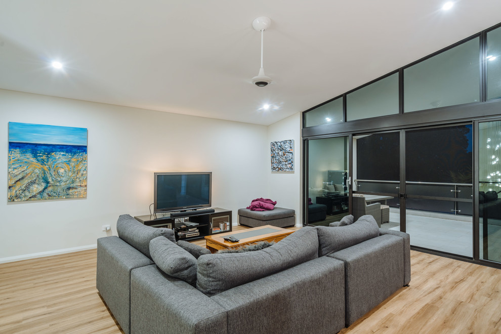 Photo of a modern open concept living room in Perth with white walls and light hardwood floors.