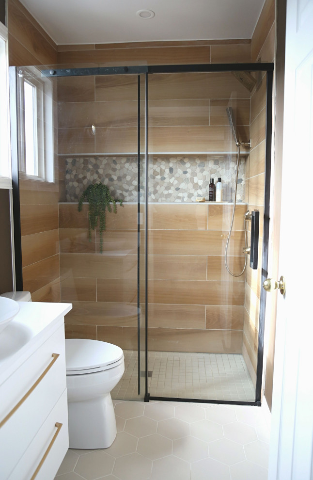 Inredning av ett modernt litet vit vitt en-suite badrum, med släta luckor, vita skåp, en kantlös dusch, en toalettstol med separat cisternkåpa, brun kakel, bruna väggar, klinkergolv i porslin, ett fristående handfat, bänkskiva i kvarts, beiget golv och dusch med skjutdörr