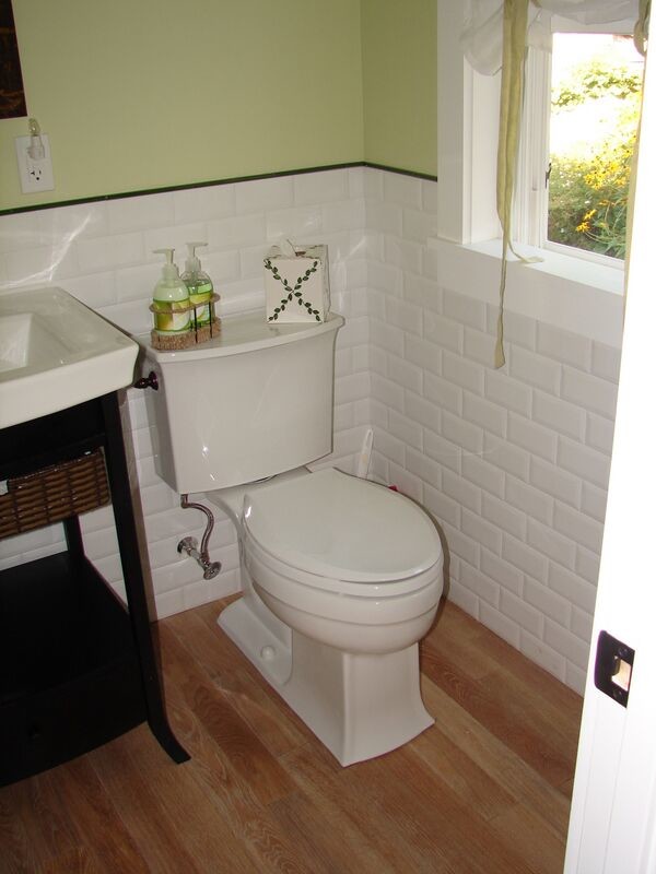 Design ideas for a small country 3/4 bathroom in Portland Maine with a pedestal sink, green walls and dark hardwood floors.