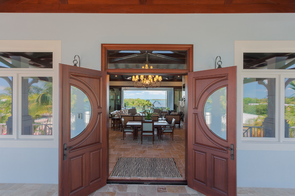 Photo of a large beach style front door in Miami with blue walls, travertine floors, a double front door, a dark wood front door and beige floor.