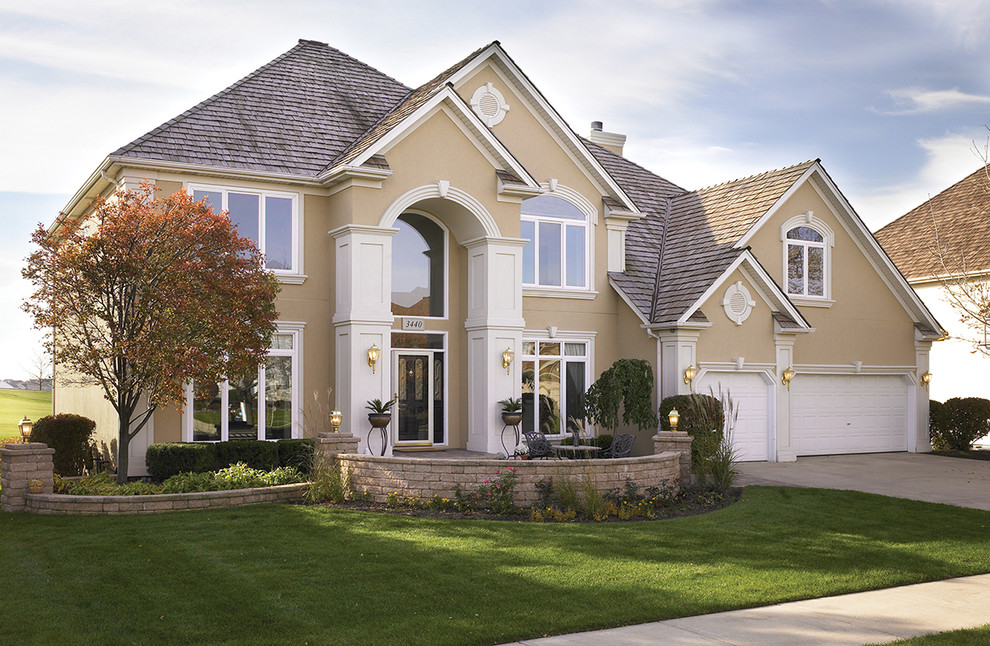 Design ideas for a large traditional two-storey stucco beige house exterior in Denver with a gable roof and a shingle roof.
