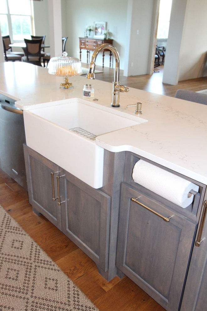 This is an example of a mid-sized transitional u-shaped separate kitchen in St Louis with an undermount sink, shaker cabinets, white cabinets, quartz benchtops, white splashback, ceramic splashback, stainless steel appliances, dark hardwood floors, with island, brown floor and white benchtop.
