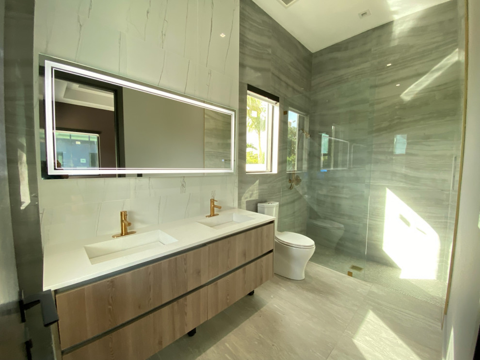 Bild på ett mellanstort funkis vit vitt badrum med dusch, med släta luckor, bruna skåp, våtrum, en toalettstol med hel cisternkåpa, flerfärgad kakel, marmorkakel, flerfärgade väggar, mosaikgolv, ett nedsänkt handfat, granitbänkskiva, flerfärgat golv och dusch med gångjärnsdörr